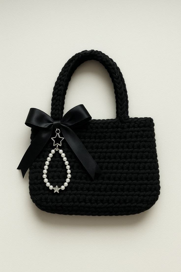 Black woven handbag with a bow and star-shaped charm on a beige background