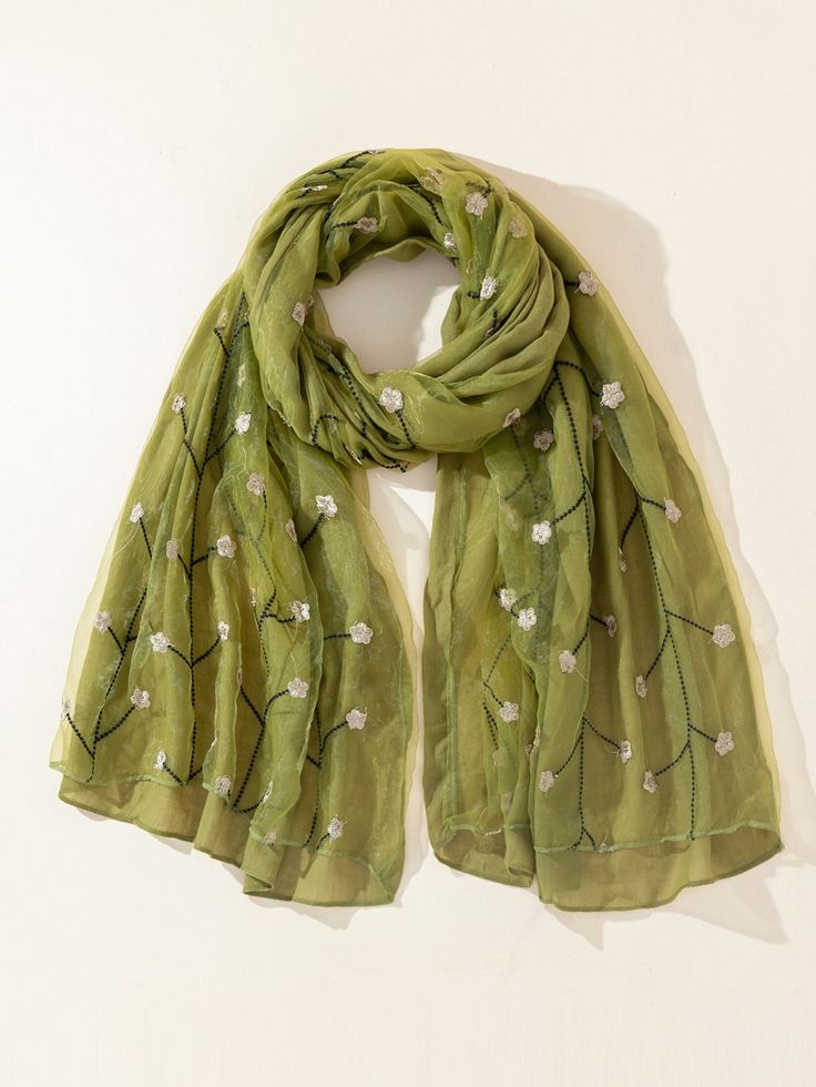 Green scarf with floral embroidery on a white background