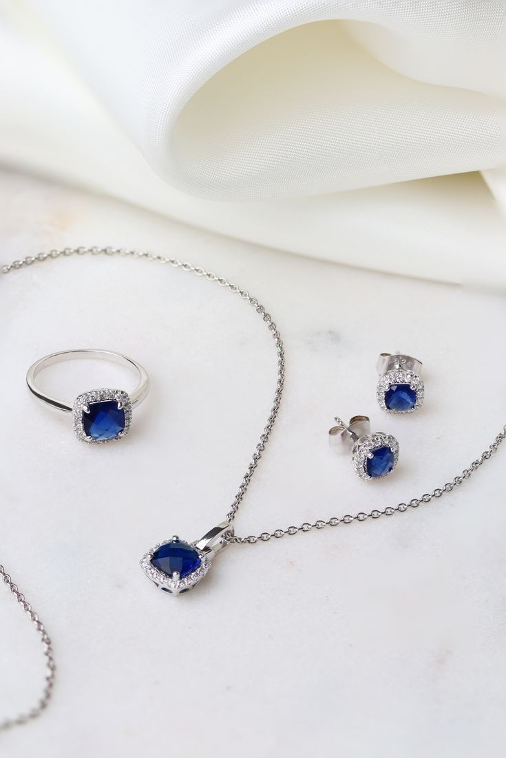 Jewelry set with blue gemstones on a white fabric background