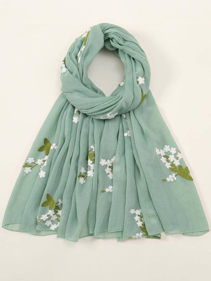 Light green scarf with floral embroidery on a white background