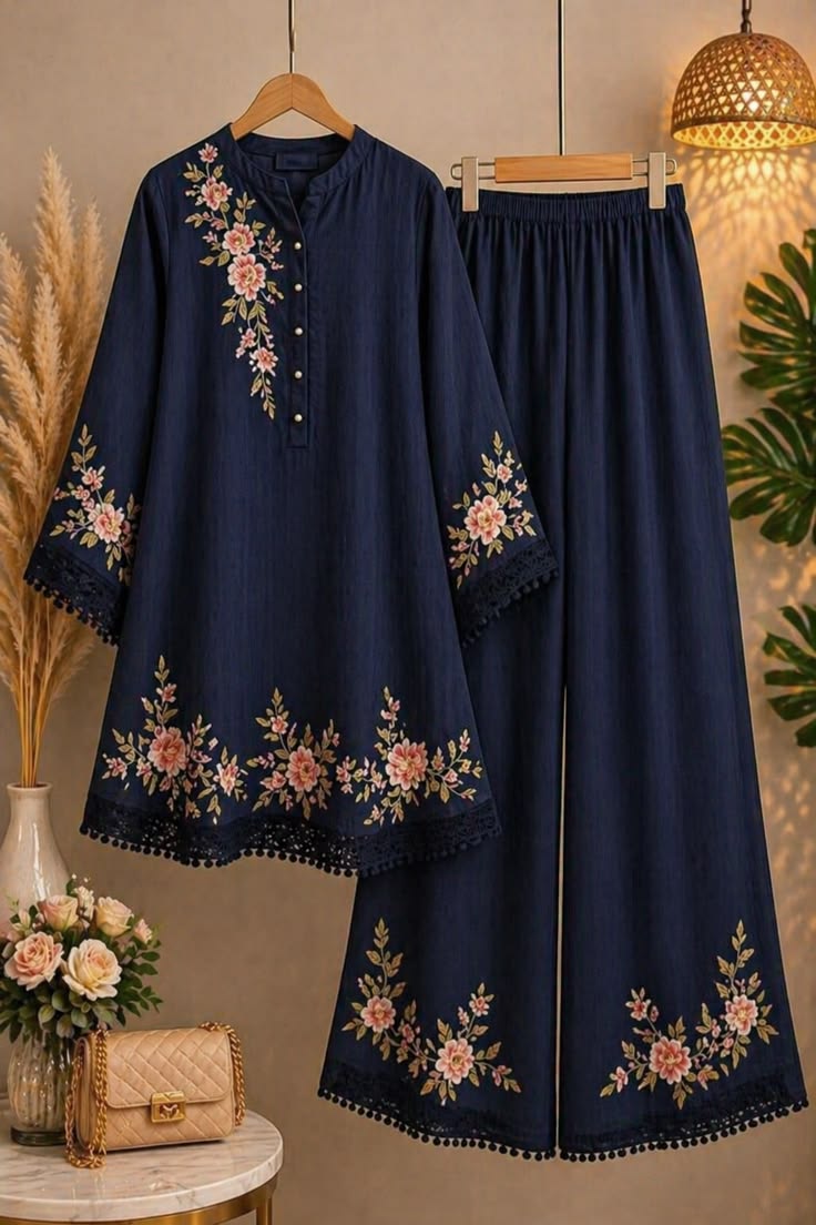 Navy blue embroidered outfit with floral patterns on a hanger against a neutral background.