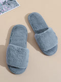 Pair of gray fluffy slippers on a beige surface