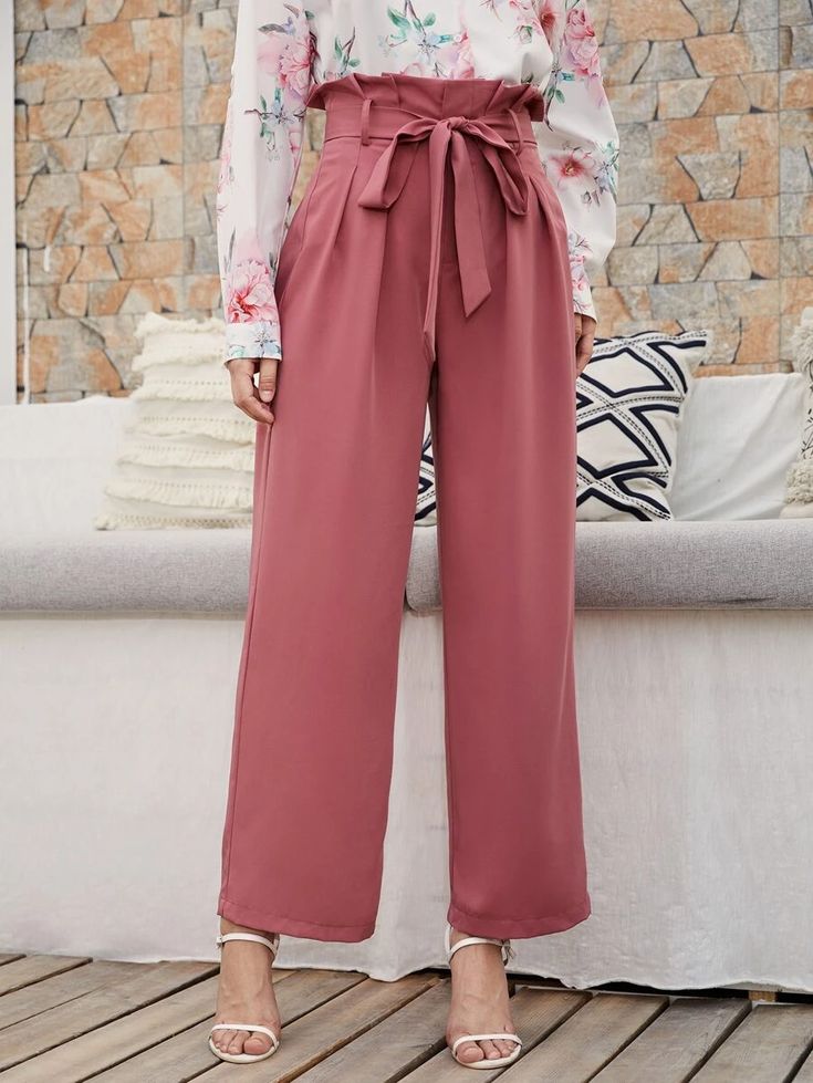 Person wearing pink wide-leg pants with a floral top in an outdoor setting.
