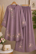 Purple embroidered outfit with matching pants on a hanger against a neutral background.
