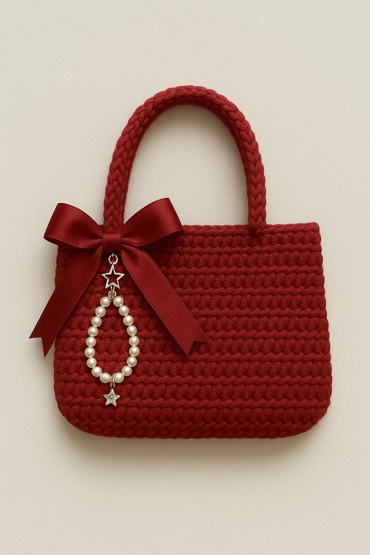 Red crochet handbag with a bow and pearl charm on a beige background
