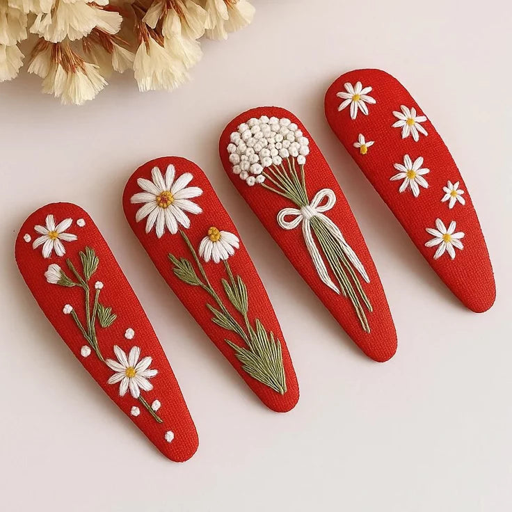 Red hair clips with floral designs on a light background