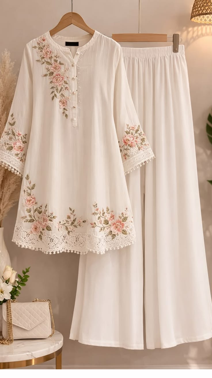 White embroidered outfit on a hanger with a neutral background