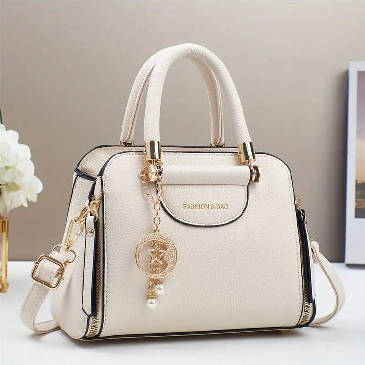 White handbag with gold accents on a light surface